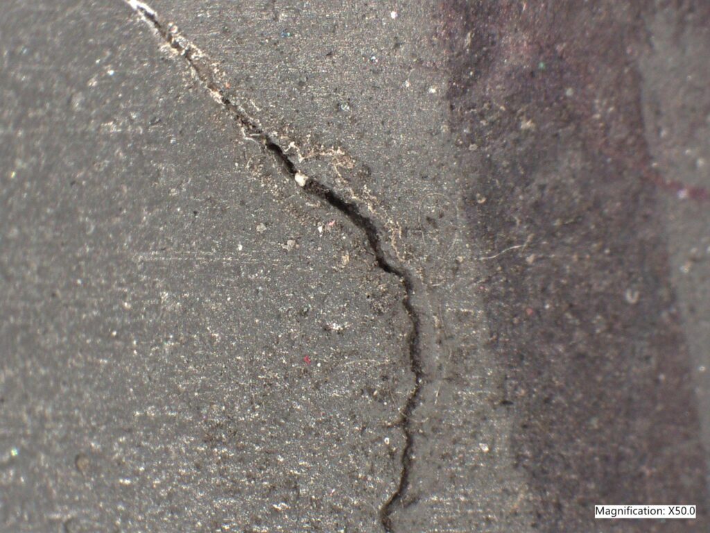 A 50x magnification image of a crack on a paper machine roll cover